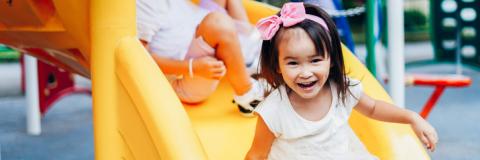 Preschool children on a yellow slide 