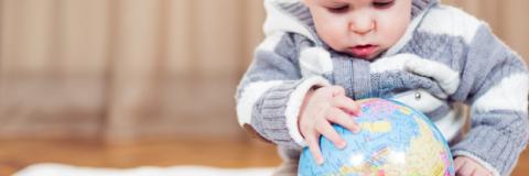 Baby explores a globe.