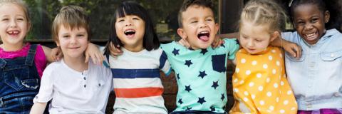 Diverse preschoolers happily sitting together. 