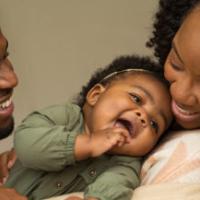 African American Family playing and laughing with their daughter.African American Family playing and laughing with their daughter. 