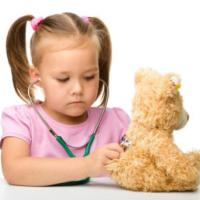 little girl is examining her teddy bear using stethoscope, isolated over white 