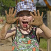 boy playing in the garden with sandy hands 