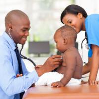 African american male pediatric doctor examining baby boy with female nurse 