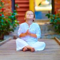 cute boy trying to find inner balance in meditation 