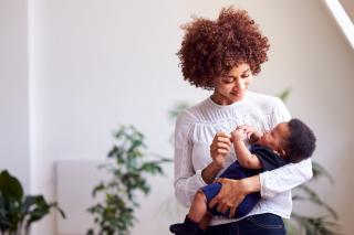 Mom smiling at infant in her arms. 