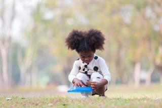 Little girl doing a STEM experiment in the park.