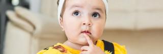 Beautiful baby latina, looking up, with a thoughtful face, searching for ideas.