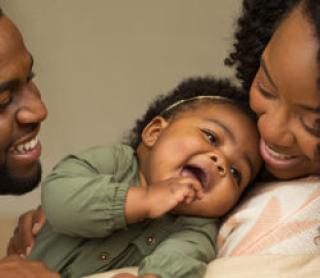 African American Family playing and laughing with their daughter.African American Family playing and laughing with their daughter. 