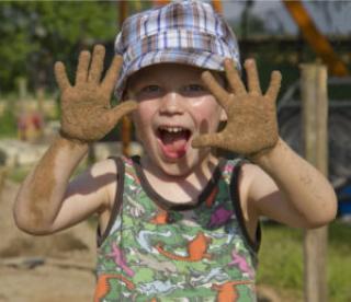 boy playing in the garden with sandy hands 