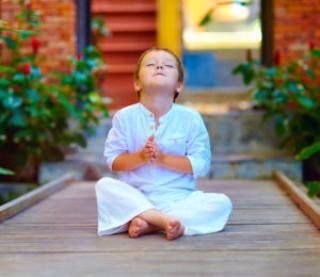 cute boy trying to find inner balance in meditation 