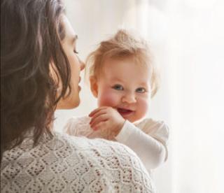 Smiling baby in mother's arms 