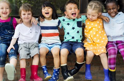 Diverse preschoolers happily sitting together. 