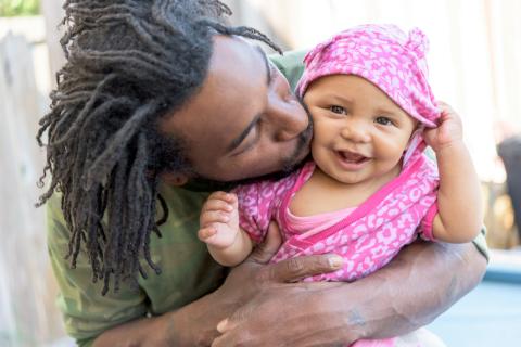 Dad kissing baby daughter, 